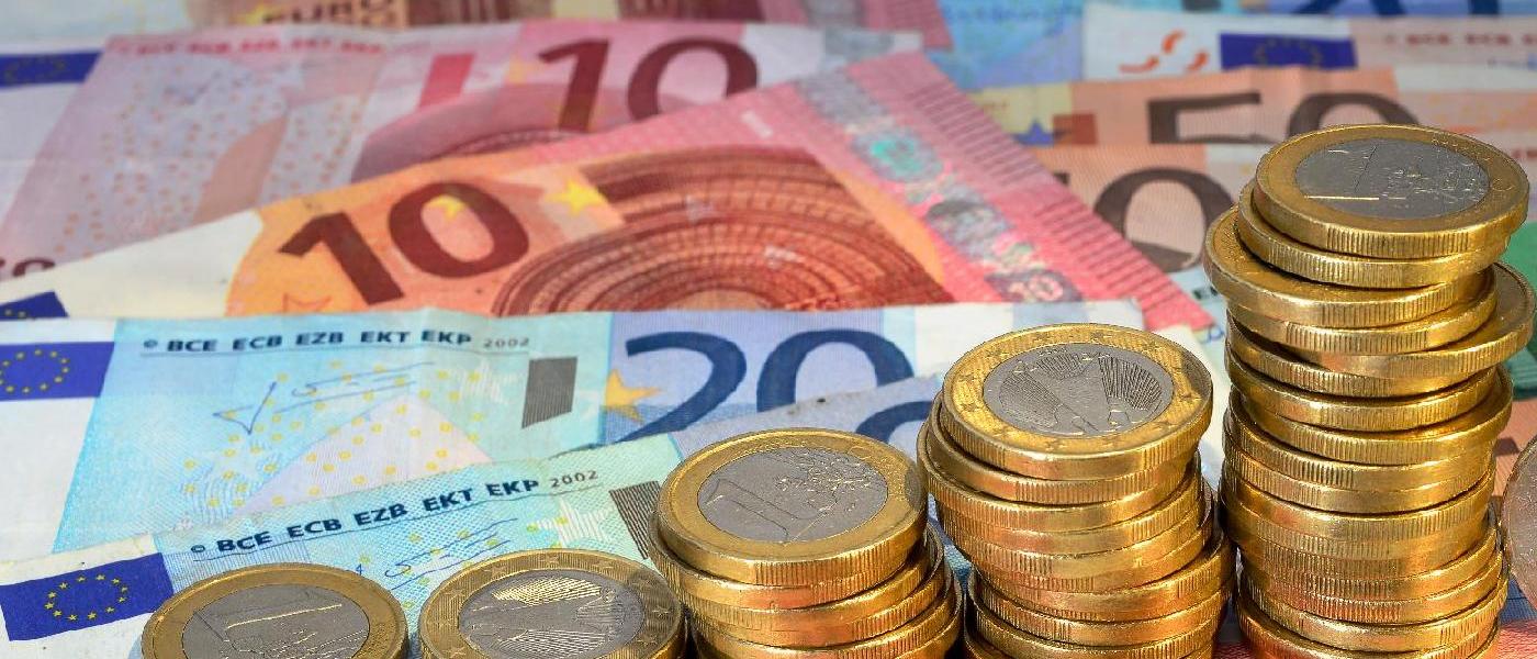 Euroscheine und Euromünzen liegen verteilt auf einem Tisch. Quelle: Xaver Klaussner/stock.adobe.com